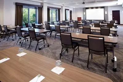 a conference room with tables and chairs and a projection screen at Hyatt Place Cleveland/Lyndhurst/Legacy Village in Lyndhurst