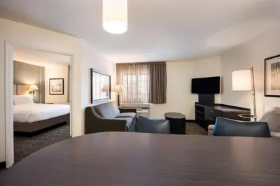 a hotel room with a table and a bed at Sonesta Simply Suites Columbus Airport Gahanna in Gahanna