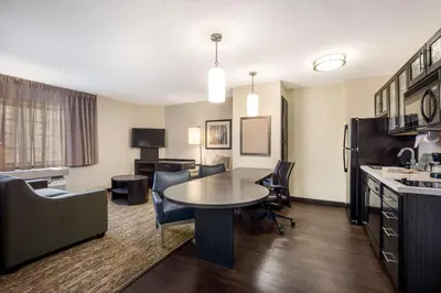 a living room with a table and chairs in a hotel room at Sonesta Simply Suites Columbus Airport Gahanna in Gahanna