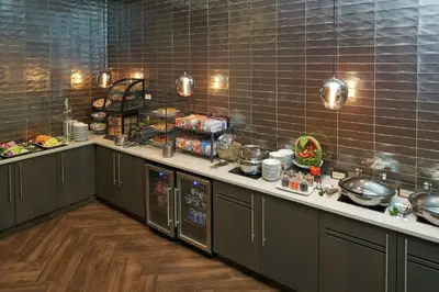 a kitchen with a counter with dishes and appliances at Hilton Cincinnati Airport in Florence