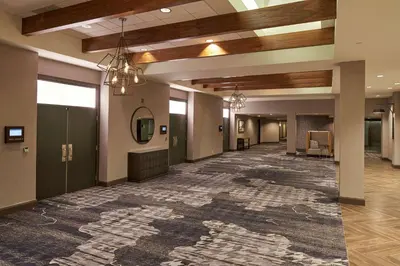 a lobby with a large rug on the floor at Hilton Cincinnati Airport in Florence