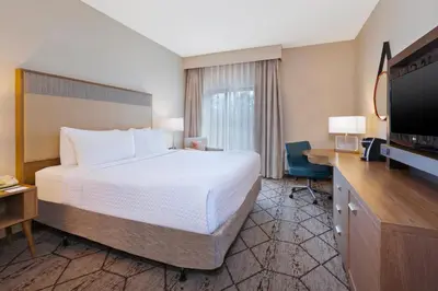 a hotel room with a bed and a flat screen tv at Crowne Plaza Columbus North - Worthington by IHG in Columbus
