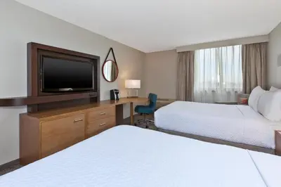 a hotel room with two beds and a flat screen tv at Crowne Plaza Columbus North - Worthington by IHG in Columbus