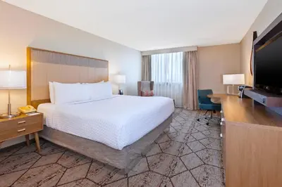 a hotel room with a bed and a flat screen tv at Crowne Plaza Columbus North - Worthington by IHG in Columbus
