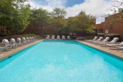 a large swimming pool with chairs and a poolside at Crowne Plaza Columbus North - Worthington by IHG in Columbus