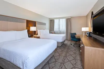 a hotel room with two beds and a flat screen tv at Crowne Plaza Columbus North - Worthington by IHG in Columbus