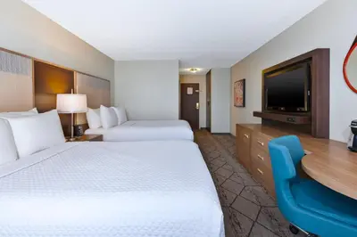 a hotel room with two beds and a flat screen tv at Crowne Plaza Columbus North - Worthington by IHG in Columbus