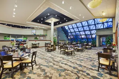 a restaurant with tables and chairs and a glass ceiling at Crowne Plaza Columbus North - Worthington by IHG in Columbus