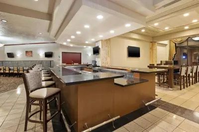 a bar in a restaurant with chairs and tables at Crowne Plaza Columbus North - Worthington by IHG in Columbus