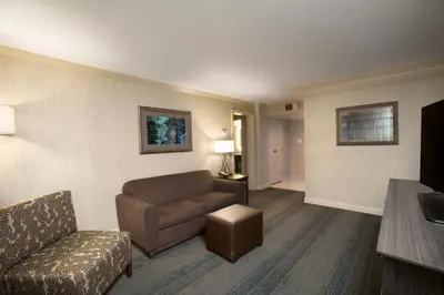 a living room with a couch and a chair at Holiday Inn Columbus Dwtn-Capitol Square by IHG in Columbus
