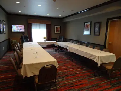 a conference room with tables and chairs and a television at Holiday Inn Express Hotel & Suites Columbus Southeast Groveport by IHG in Groveport