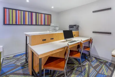 an office with a desk with a laptop and two chairs at Holiday Inn Express Columbus - Ohio Expo Center by IHG in Columbus