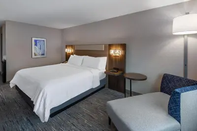 a hotel room with a large bed and a chair at Holiday Inn Express & Suites Wadsworth by IHG in Wadsworth