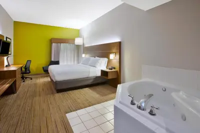 a hotel room with a bed and a bath tub at Holiday Inn Express Hotel & Suites Cincinnati Northeast-Milford by IHG in Milford
