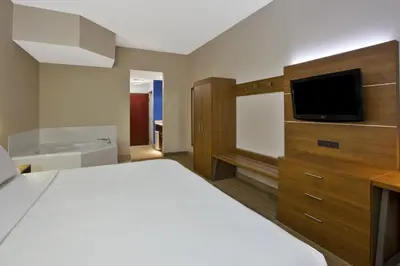 a hotel room with a bed and a flat screen tv at Holiday Inn Express Hotel & Suites Cincinnati Northeast-Milford by IHG in Milford