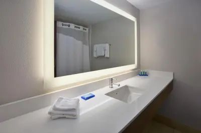 a white bathroom with a sink and a mirror at Holiday Inn Express Hotel & Suites Cincinnati Northeast-Milford by IHG in Milford