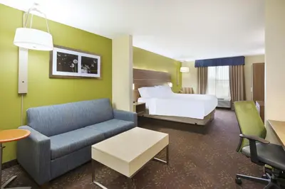 a hotel room with a bed and a couch at Holiday Inn Express Hotel & Suites Circleville by IHG in Circleville