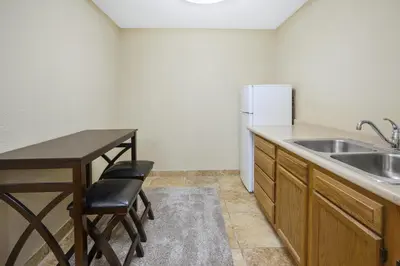 a kitchen with a sink and a table and a refrigerator at Holiday Inn Express Hotel & Suites Circleville by IHG in Circleville