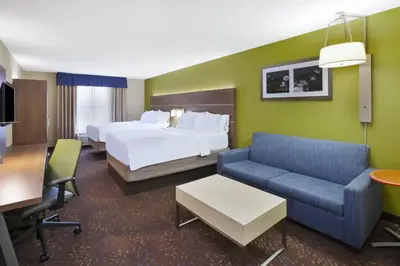 a hotel room with two beds and a couch at Holiday Inn Express Hotel & Suites Circleville by IHG in Circleville