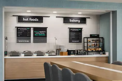 a restaurant with a counter with hot foods and a bakery at Holiday Inn Columbus-Hilliard by IHG in New Rome