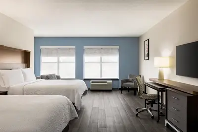 a hotel room with two beds and a flat screen tv at Holiday Inn Columbus-Hilliard by IHG in New Rome