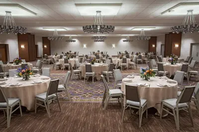 a banquet hall with tables and chairs and chandeliers at Sheraton Pittsburgh Airport Hotel in Coraopolis
