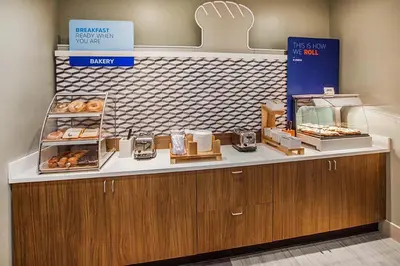 a bakery with a counter with donuts on it at Holiday Inn Express Hotel & Suites Grove City by IHG in Grove City