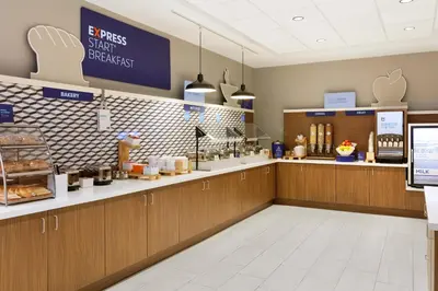 a fast food restaurant with a counter with food at Holiday Inn Express Hotel & Suites Grove City by IHG in Grove City