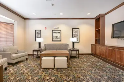 a waiting room with a couch and a tv at Staybridge Suites Akron-Stow-Cuyahoga Falls by IHG in Stow