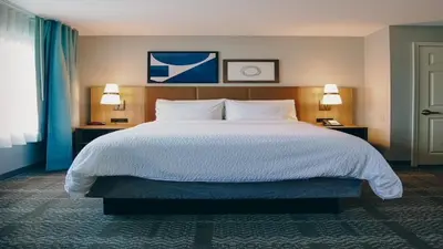 a large bed in a hotel room with two lamps at Staybridge Suites Akron-Stow-Cuyahoga Falls by IHG in Stow