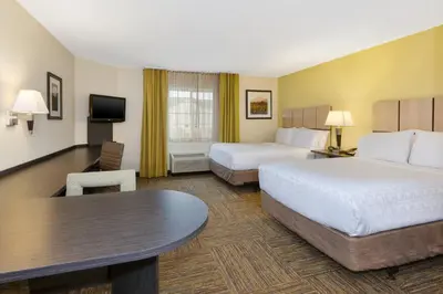 a hotel room with two beds and a table at Candlewood Suites Polaris by IHG in Columbus