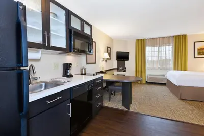 a hotel room with a kitchen and a bedroom at Candlewood Suites Polaris by IHG in Columbus
