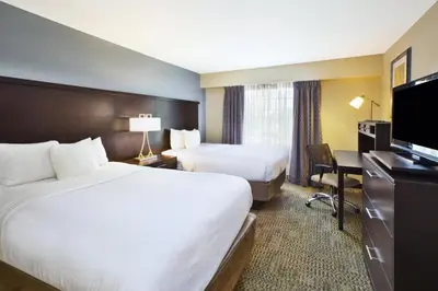 a hotel room with two beds and a desk at Staybridge Suites Cleveland Mayfield Heights Beachwood by IHG in Mayfield Heights