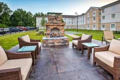 a patio with chairs and a fireplace in front of a building at Staybridge Suites Cleveland Mayfield Heights Beachwood by IHG in Mayfield Heights