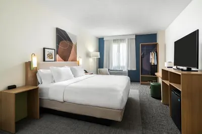 a hotel room with a bed and a flat screen tv at Spark By Hilton Akron Fairlawn in Fairlawn
