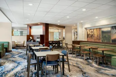 a restaurant with tables and chairs in a room at Fairfield Inn & Suites by Marriott Cincinnati Uptown/University Area in Cincinnati