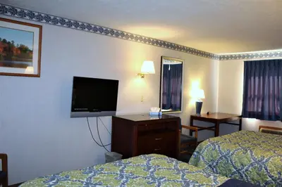 a hotel room with two beds and a flat screen tv at Americas Best Value Inn of Decatur in Decatur