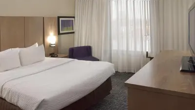 a hotel room with a large bed and a desk at Crowne Plaza Cleveland Airport by IHG in Middleburg Heights