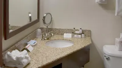 a bathroom with a sink and a mirror at Crowne Plaza Cleveland Airport by IHG in Middleburg Heights