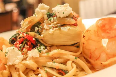 a plate of pasta and shrimp on a plate at Crowne Plaza Cleveland Airport by IHG in Middleburg Heights