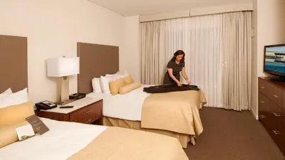 a woman standing on a bed in a hotel room at InterContinental Suites Hotel Cleveland by IHG in Cleveland