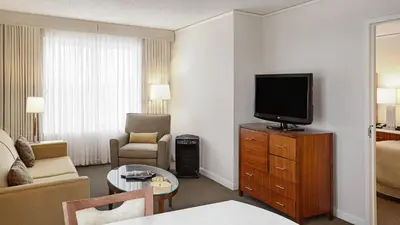 a living room with a television on a dresser at InterContinental Suites Hotel Cleveland by IHG in Cleveland