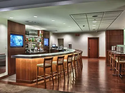 a bar in a restaurant with wooden floors and chairs at InterContinental Suites Hotel Cleveland by IHG in Cleveland