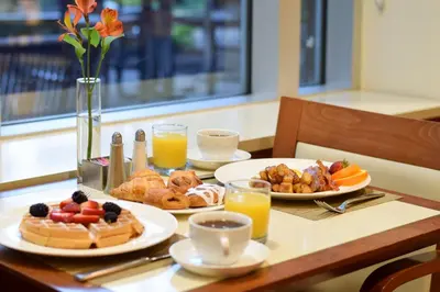 a table with plates of breakfast foods and orange juice at InterContinental Suites Hotel Cleveland by IHG in Cleveland