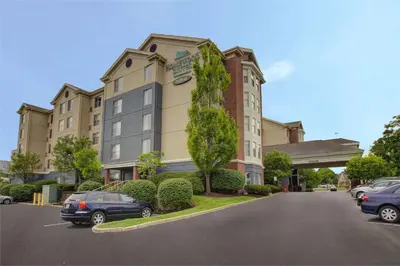 a building with cars parked in a parking lot at Homewood Suites by Hilton Dayton South in Miamisburg