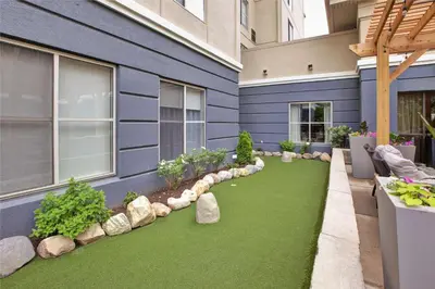 a garden with artificial grass and rocks on the side of a building at Homewood Suites by Hilton Dayton South in Miamisburg