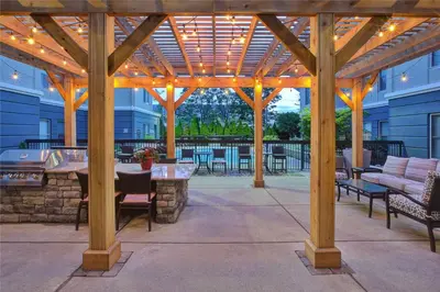 a patio with a wooden pergola with a table and chairs at Homewood Suites by Hilton Dayton South in Miamisburg