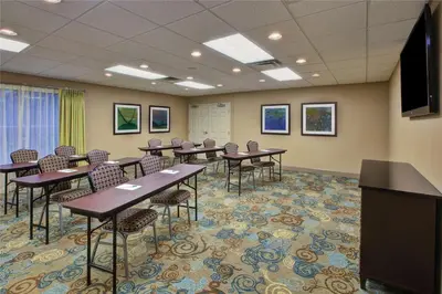 a conference room with tables and chairs and a flat screen tv at Homewood Suites by Hilton Dayton South in Miamisburg