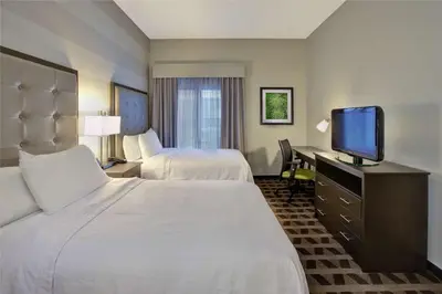 a hotel room with two beds and a flat screen tv at Homewood Suites by Hilton Dayton South in Miamisburg