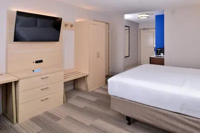 a bedroom with a bed and a desk with a television at Holiday Inn Express Hotel & Suites Cincinnati - Mason by IHG in Mason